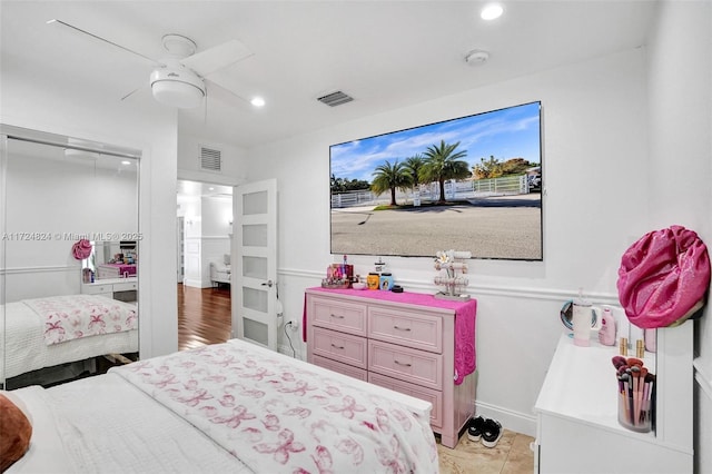 tiled bedroom featuring ceiling fan and a closet