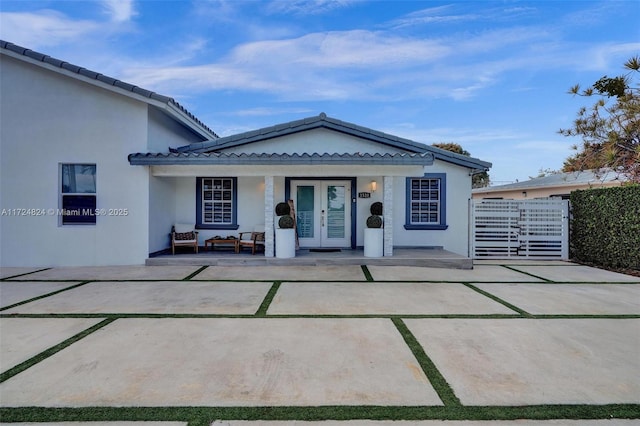 view of front of house with covered porch and french doors