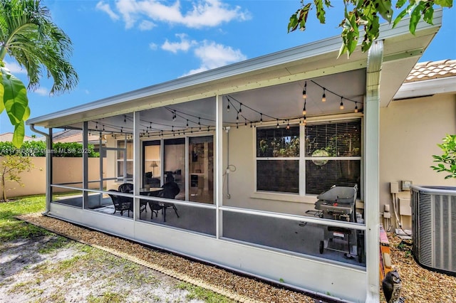 rear view of house with a sunroom and central AC unit