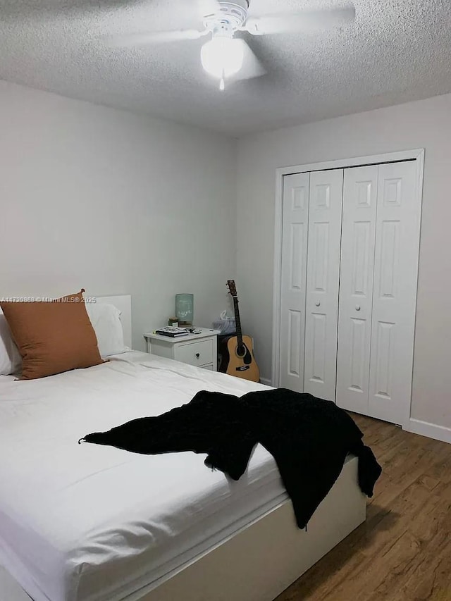 bedroom featuring a closet, ceiling fan, dark wood-type flooring, and a textured ceiling