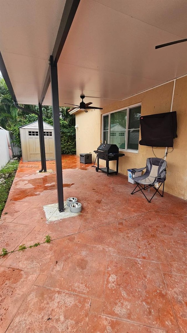 view of patio / terrace featuring area for grilling, ceiling fan, and a shed