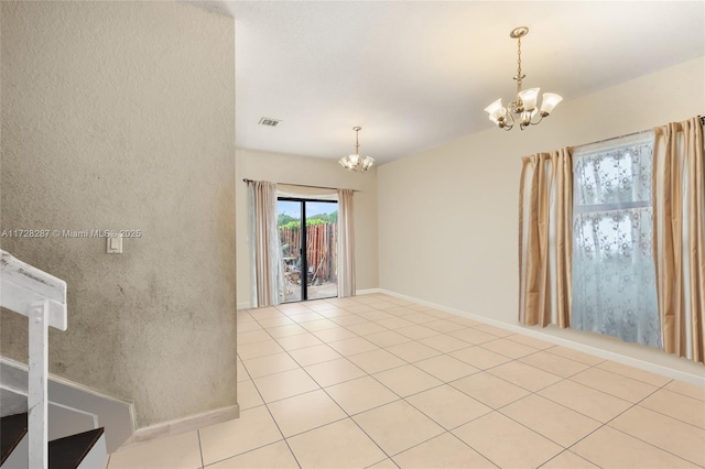 unfurnished room with a chandelier and light tile patterned floors