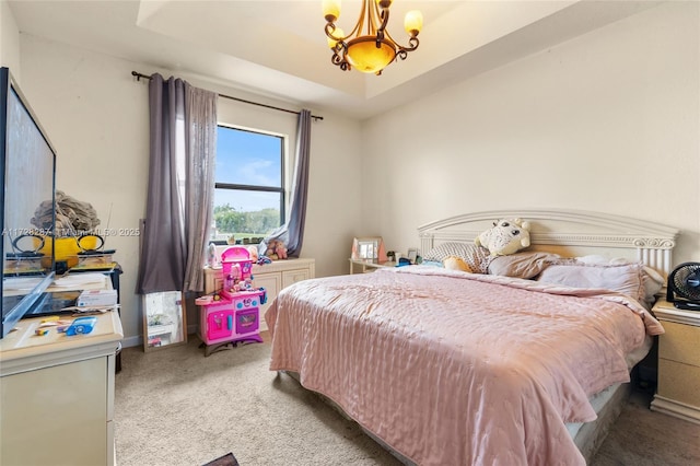 carpeted bedroom featuring a chandelier and a tray ceiling