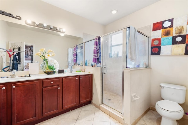 bathroom with a shower with shower door, toilet, vanity, and tile patterned flooring