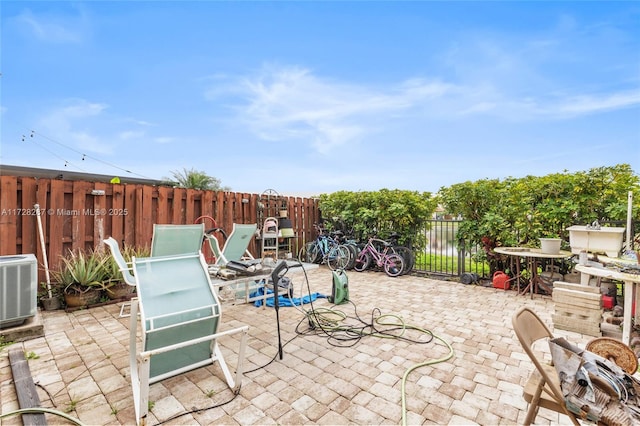 view of patio / terrace featuring central air condition unit and a water view