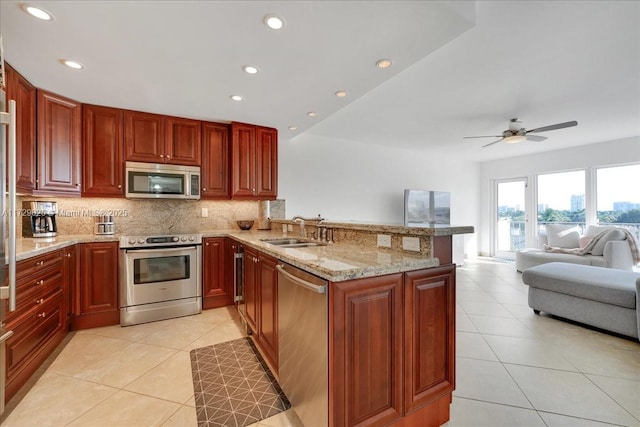 kitchen with sink, light tile patterned floors, appliances with stainless steel finishes, backsplash, and kitchen peninsula