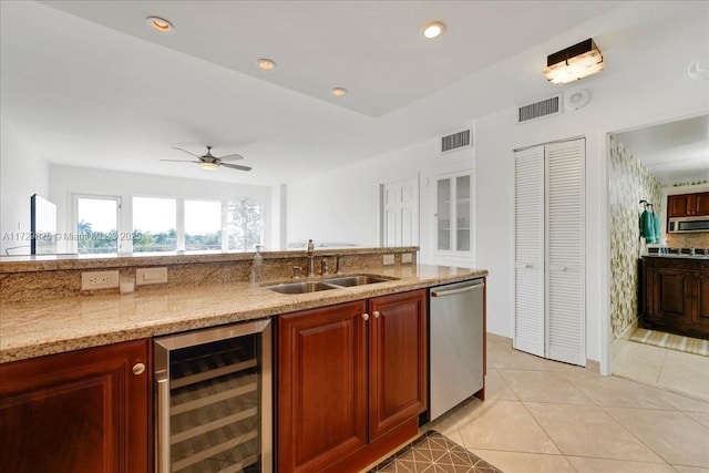 kitchen featuring sink, light tile patterned floors, stainless steel appliances, light stone countertops, and beverage cooler