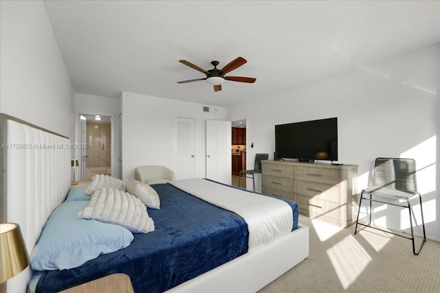 carpeted bedroom featuring ceiling fan and connected bathroom