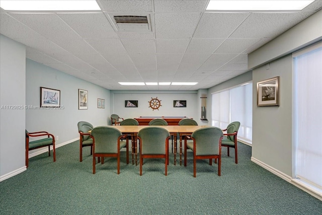 carpeted dining room with a paneled ceiling