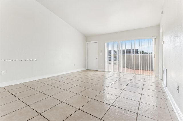 tiled spare room with lofted ceiling