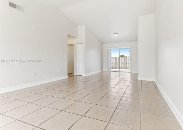 spare room featuring light tile patterned floors and lofted ceiling