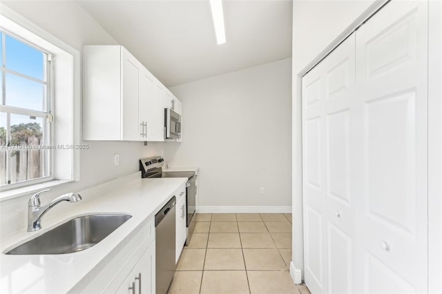 kitchen with sink, light tile patterned flooring, white cabinetry, and appliances with stainless steel finishes