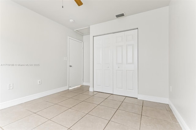 unfurnished bedroom featuring a closet, light tile patterned floors, and ceiling fan