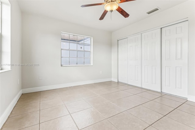 unfurnished bedroom featuring light tile patterned flooring, a closet, and ceiling fan