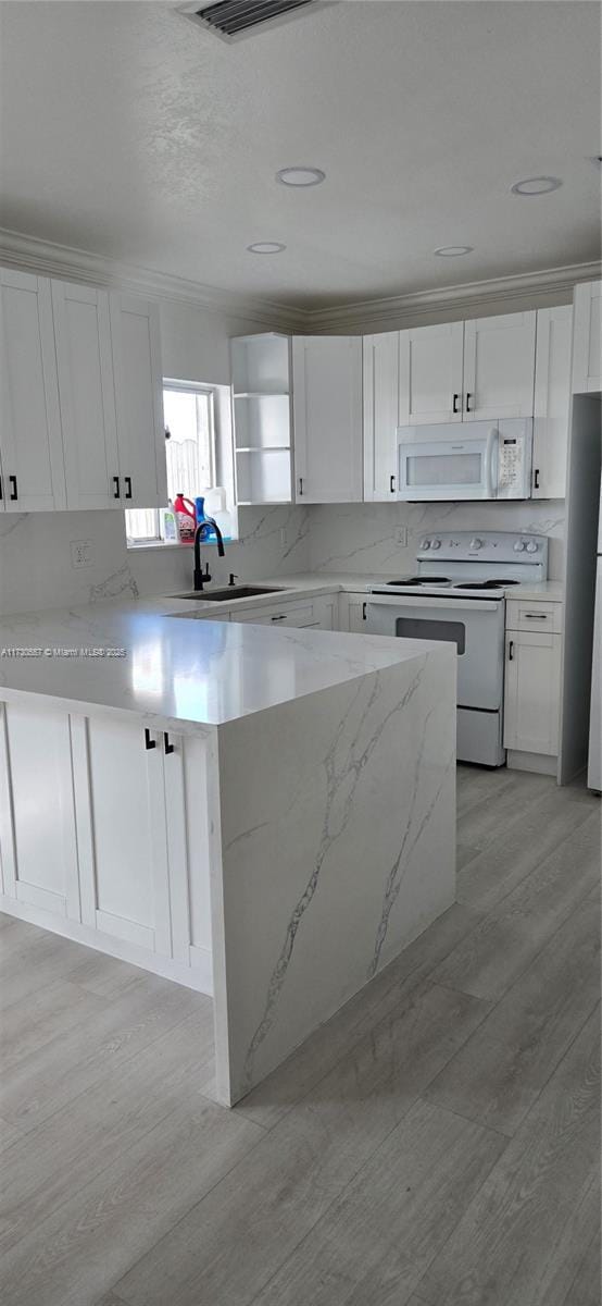 kitchen featuring sink, light wood-type flooring, white cabinetry, light stone countertops, and white appliances