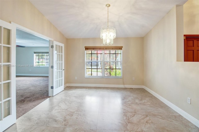 empty room featuring marble finish floor, french doors, baseboards, and an inviting chandelier