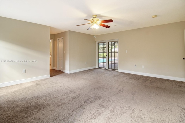 spare room featuring baseboards, a ceiling fan, and carpet
