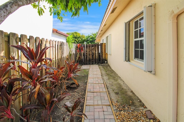 view of side of property with stucco siding and a fenced backyard