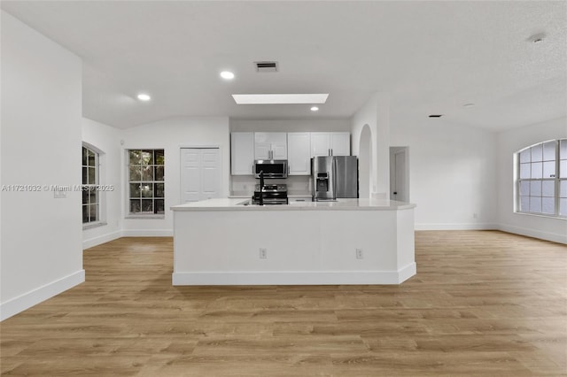 kitchen with light hardwood / wood-style floors, white cabinetry, a wealth of natural light, and stainless steel appliances