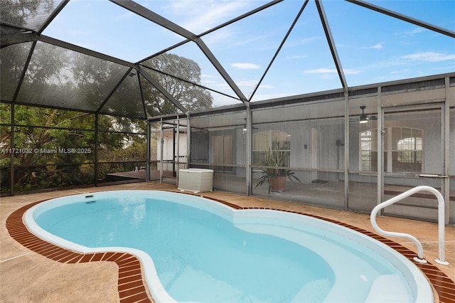 view of swimming pool featuring a patio and glass enclosure