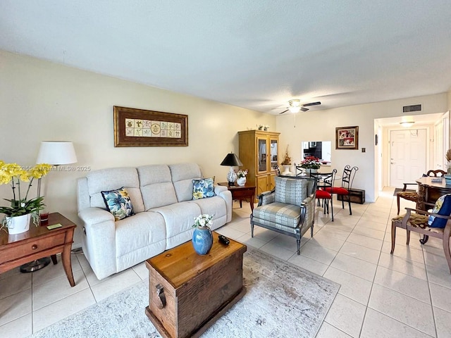 living room featuring ceiling fan, a textured ceiling, and light tile patterned floors