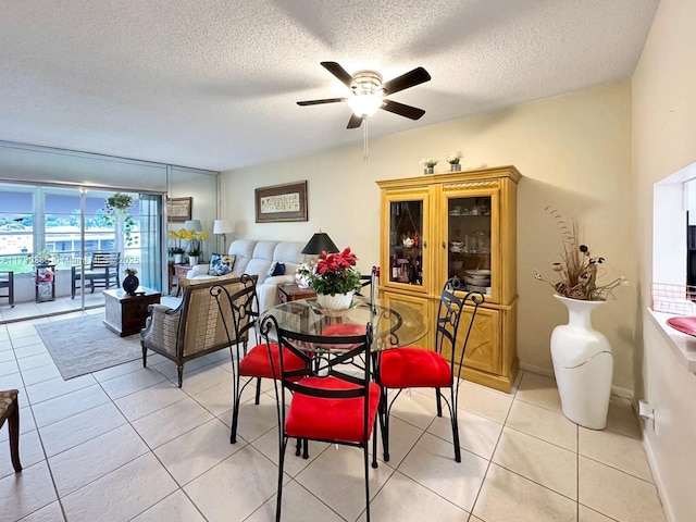 tiled dining space featuring ceiling fan and a textured ceiling