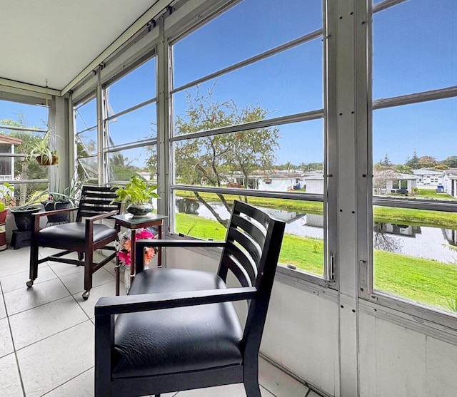 sunroom featuring a water view