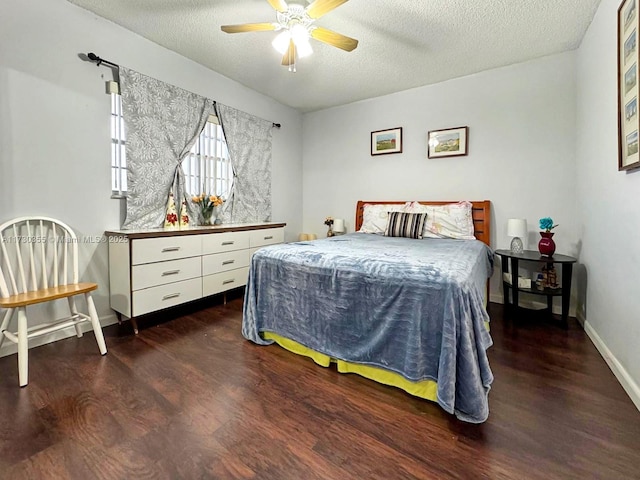 bedroom with ceiling fan, a textured ceiling, and dark hardwood / wood-style floors