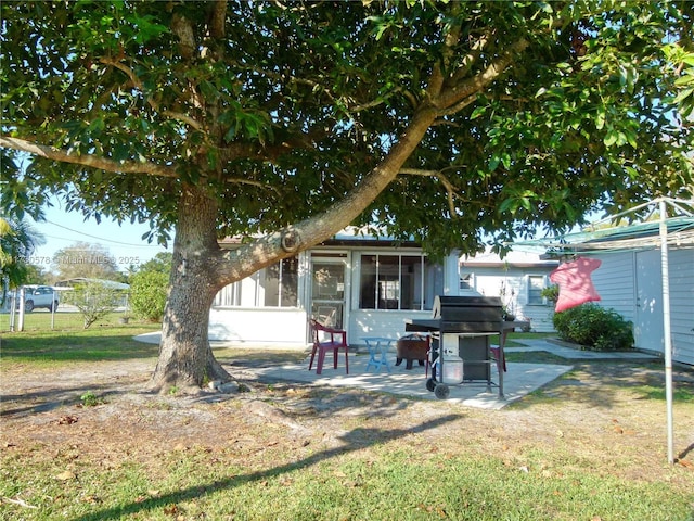 exterior space featuring a front yard, a sunroom, and a patio