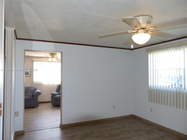 unfurnished room featuring wood-type flooring, ceiling fan, and crown molding