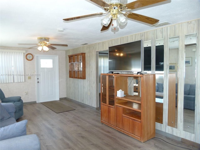 living room featuring wood-type flooring and ceiling fan