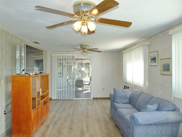 living room featuring a healthy amount of sunlight, a textured ceiling, and light wood-type flooring