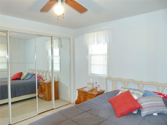 carpeted bedroom featuring ceiling fan and a closet