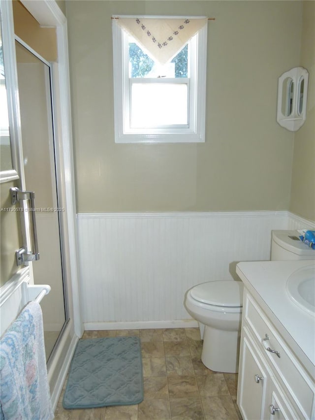 bathroom featuring vanity, toilet, and an enclosed shower