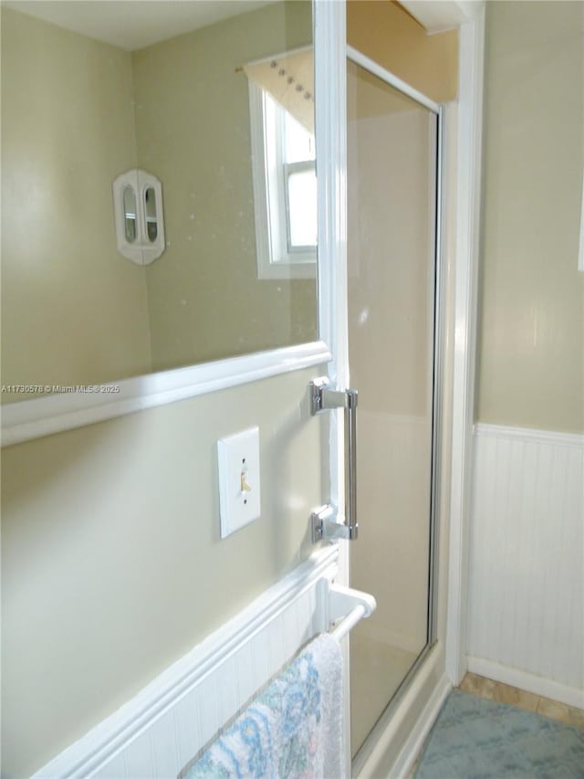 bathroom with tile patterned floors and a shower with shower door