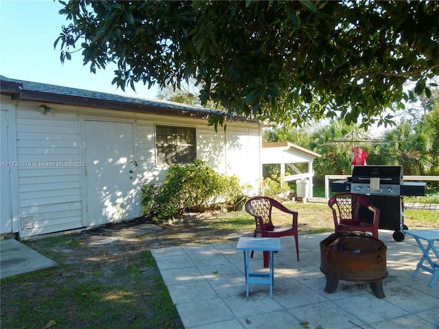 view of patio / terrace with an outdoor structure, grilling area, and an outdoor fire pit