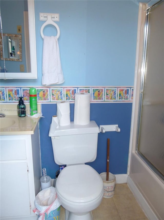 full bathroom featuring enclosed tub / shower combo, vanity, toilet, and tile patterned flooring