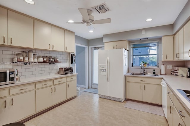 kitchen featuring sink, decorative backsplash, ceiling fan, white appliances, and cream cabinetry