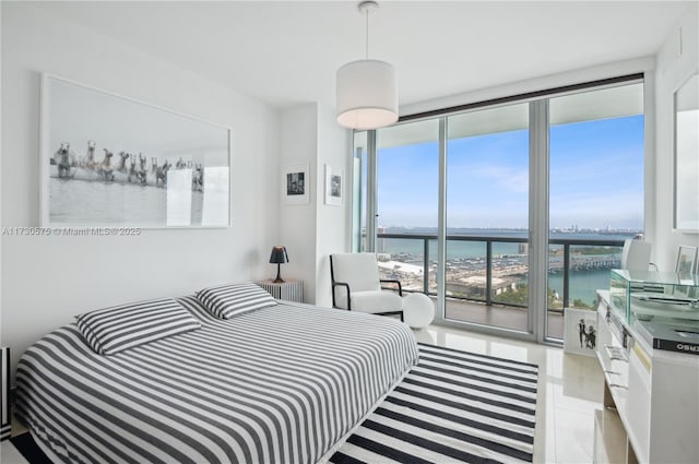 bedroom featuring a water view and a wall of windows