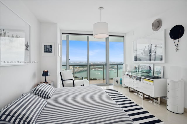 bedroom with a water view and expansive windows