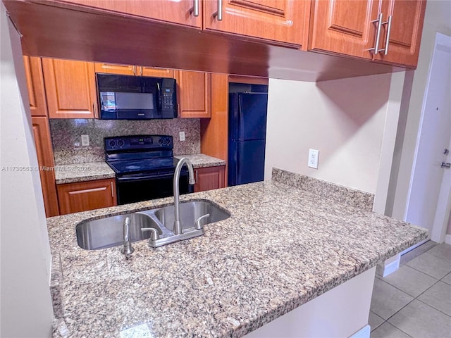 kitchen featuring decorative backsplash, sink, black appliances, and light tile patterned flooring