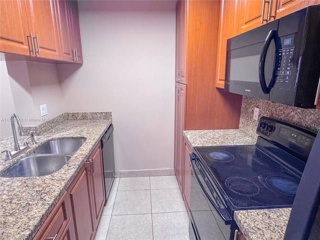 kitchen featuring sink, tasteful backsplash, light tile patterned floors, light stone counters, and black appliances