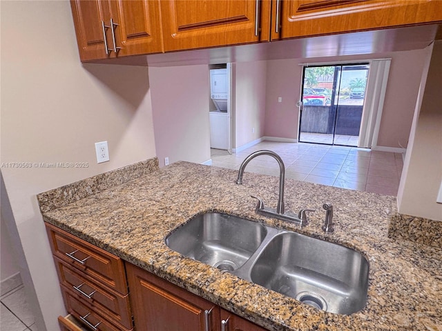 kitchen with sink, stone countertops, and light tile patterned flooring