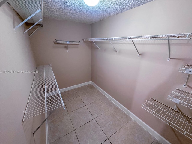 spacious closet with light tile patterned floors