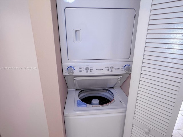 washroom featuring stacked washer / dryer and light tile patterned floors