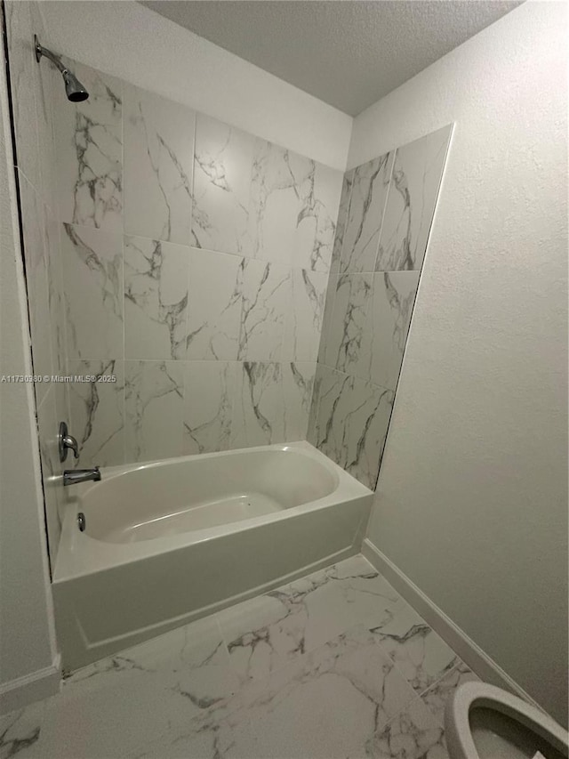 bathroom featuring toilet, a textured ceiling, and bathing tub / shower combination