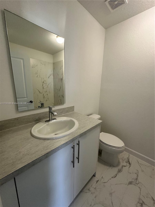 bathroom featuring vanity, toilet, and a textured ceiling