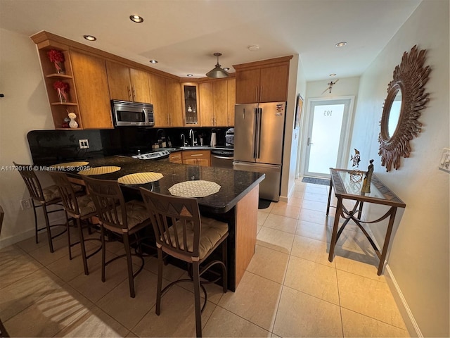 kitchen featuring kitchen peninsula, sink, light tile patterned floors, and stainless steel appliances