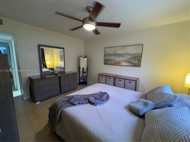 tiled bedroom featuring ceiling fan