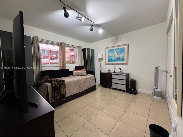 bedroom featuring rail lighting and light tile patterned floors